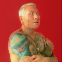 a man with tattoos and a red background